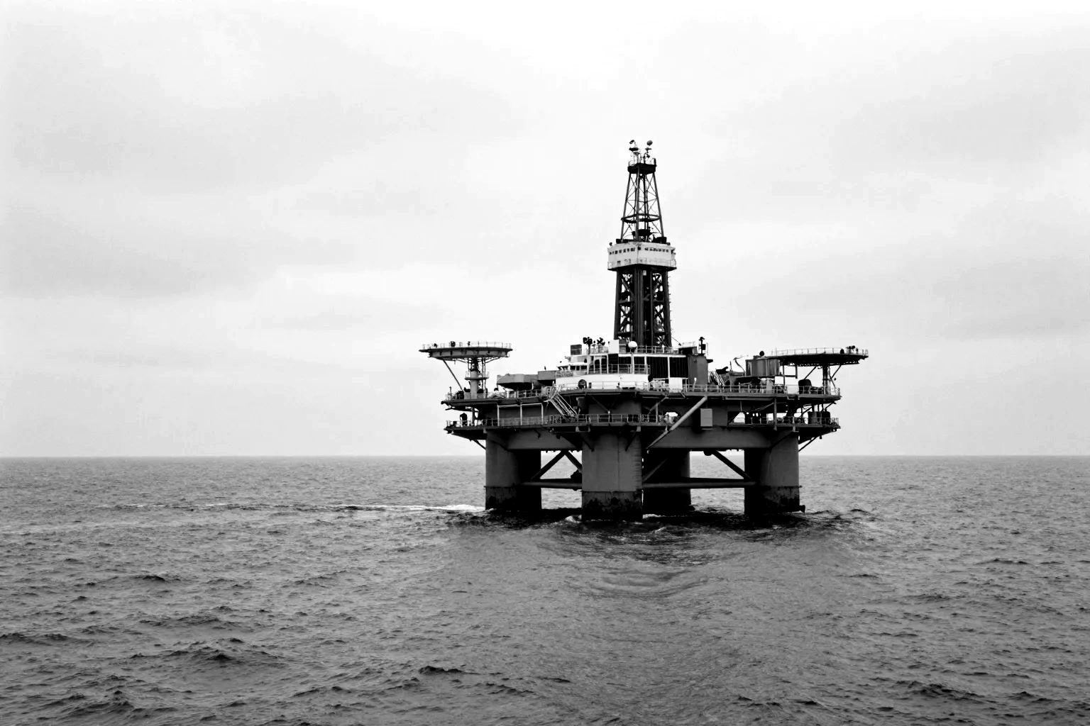 An offshore oil platform standing in grey open sea.